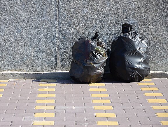 two-black-garbage-bags-on-tiled-street-floor-at-co-UDGDAKL.jpg  